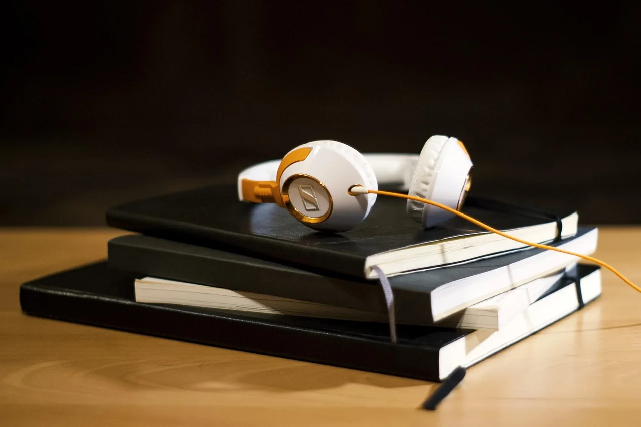 headphones, notepad, notebook, audio, black laptop, black headphones. Podcast sponsorship deals: disclosure and contract terms