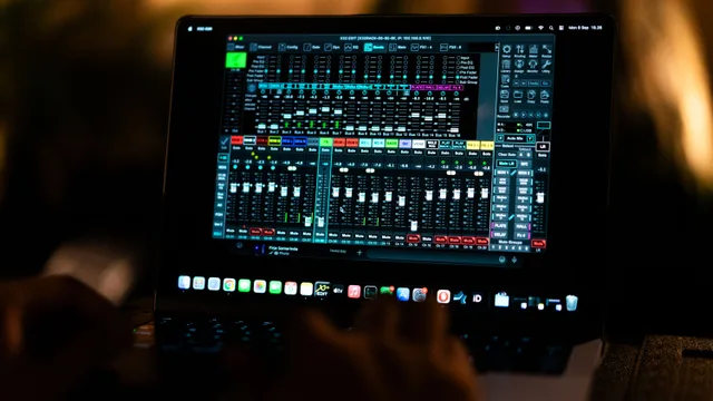 Close-up of a digital audio mixing software interface on a laptop screen in a recording studio. Podcast editor contract clauses US creators should review